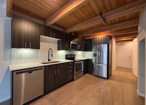 A kitchen with wooden floors and stainless steel appliances at B Flats Apartments, Bremerton, 98337