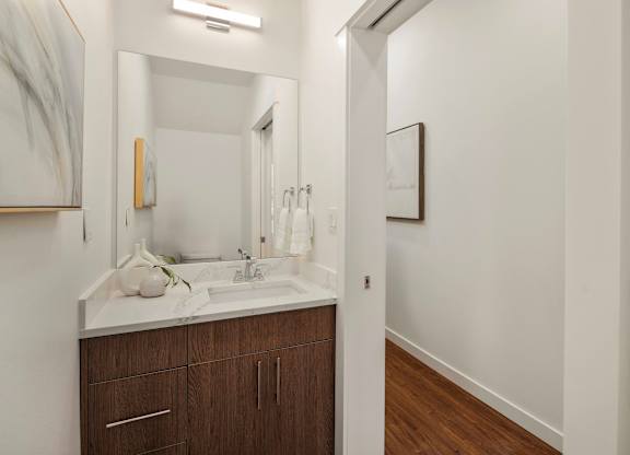 A bathroom with a white sink and brown cabinets. at The Narrows at Clare Apartments , Bremerton, WA, 98310