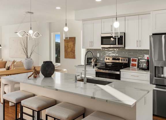 A modern kitchen with a white island and stainless steel appliances. at The Narrows at Clare Apartments , Bremerton