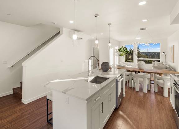 A modern kitchen with white cabinets and a large island. at The Narrows at Clare Apartments , Bremerton, WA, 98310