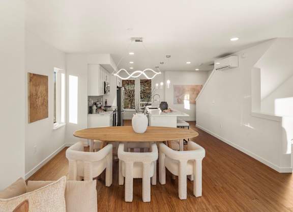A dining room with a wooden table and white chairs. at The Narrows at Clare Apartments , Bremerton, Washington