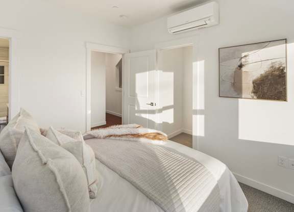 A bedroom with a large bed and a painting on the wall. at The Narrows at Clare Apartments , Washington