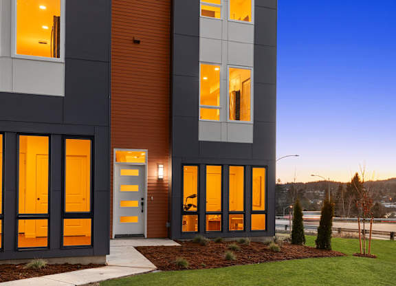 A modern house with a dark grey and white exterior and a brown door at The Narrows at Clare Apartments , Bremerton, WA, 98310