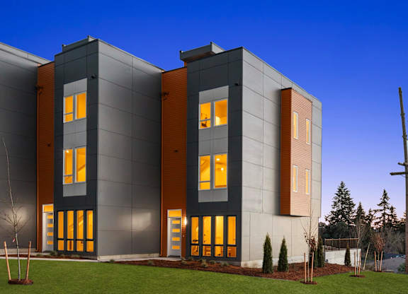 A modern building with a grey facade and orange accents at The Narrows at Clare Apartments , Washington