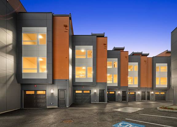 A modern building with a parking lot in front at The Narrows at Clare Apartments , Washington, 98310