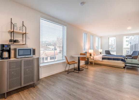 a bedroom with a bed and a tv in a room with a table and chairs at Marina Square, Bremerton, WA