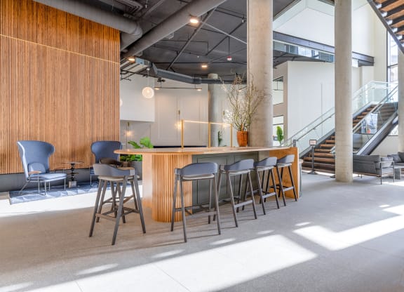 a bar area with stools and chairs and a staircase in the background at Marina Square, Bremerton