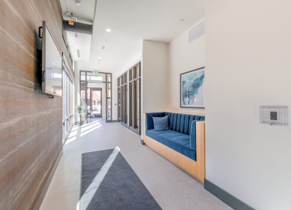 a long corridor with a blue couch on the left and a tv on the right at Marina Square, Washington, 98337