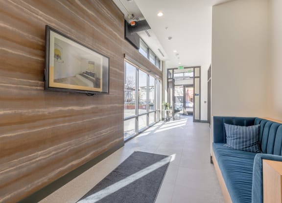 Hallway lobby with artistically textured walls and blue velvet loveseat at Marina Square, Bremerton