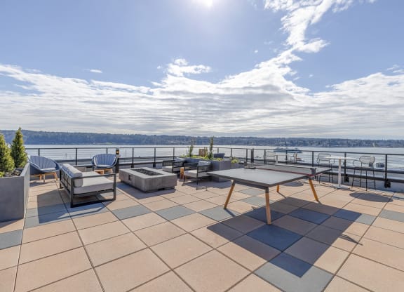 a large terrace with a ping pong  at Marina Square, Bremerton, WAtable and a view of the water