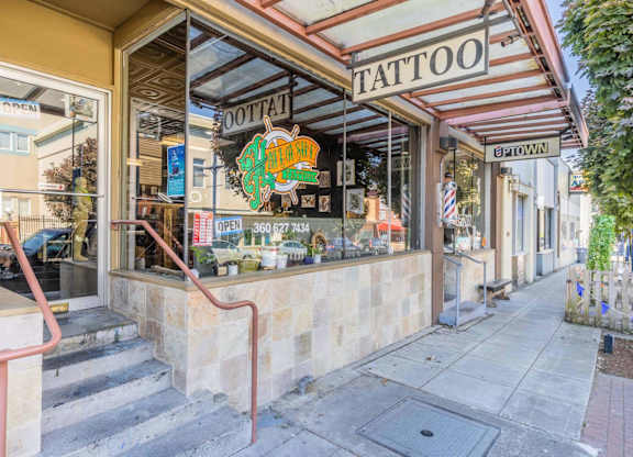 A tattoo shop with a red staircase leading to the entrance.