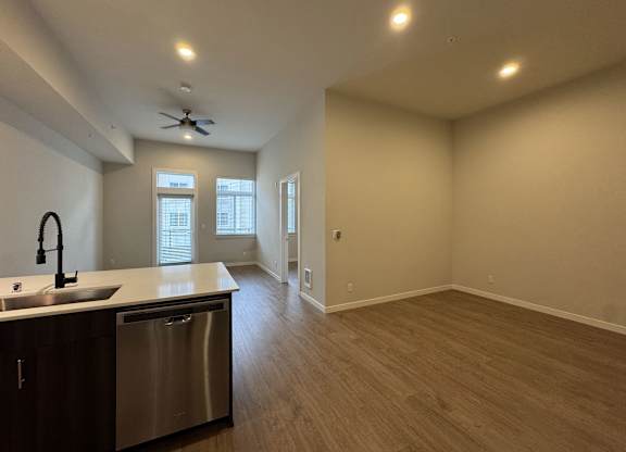 A kitchen with a stainless steel sink and dishwasher at B Flats Apartments, Washington 98337
