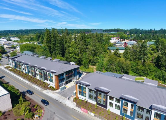 an aerial view of a building with green trees in the background and a road in the foreground at Rivulet, Silverdale Washington
