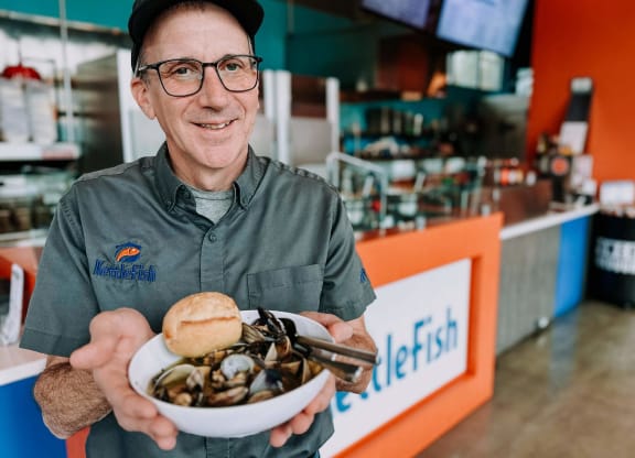 a man holding a bowl of clams at Rivulet, Washington
