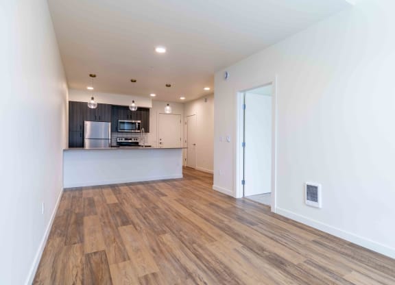 a living room and kitchen with a wood floor and white walls at Rivulet, Silverdale, 98383