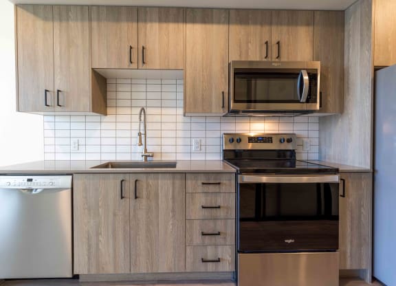 a kitchen with wooden cabinets and a stove and a microwave at Rivulet, Silverdale Washington