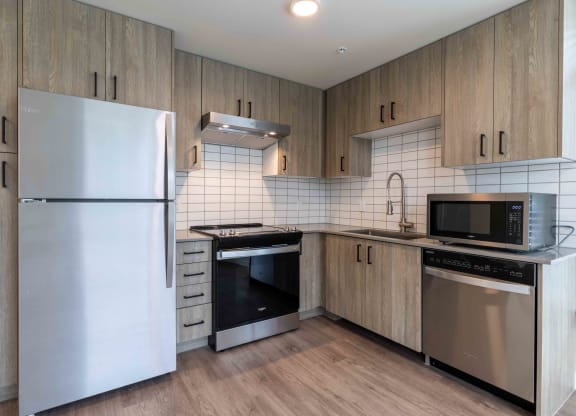 a kitchen with stainless steel appliances and wooden cabinets at Rivulet, Silverdale, 98383