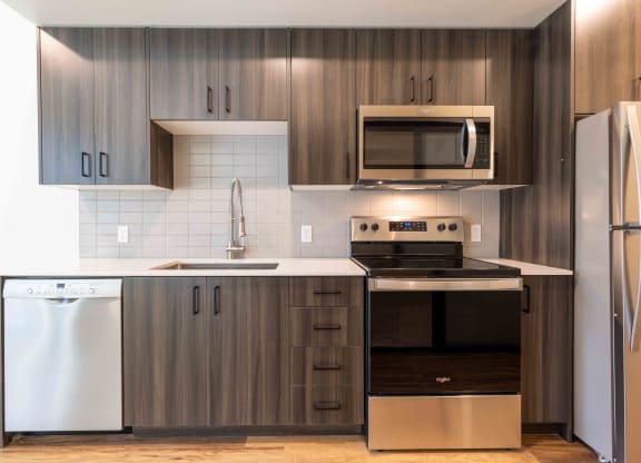 a modern kitchen with stainless steel appliances and wooden cabinets  at Rivulet, Silverdale, Washington