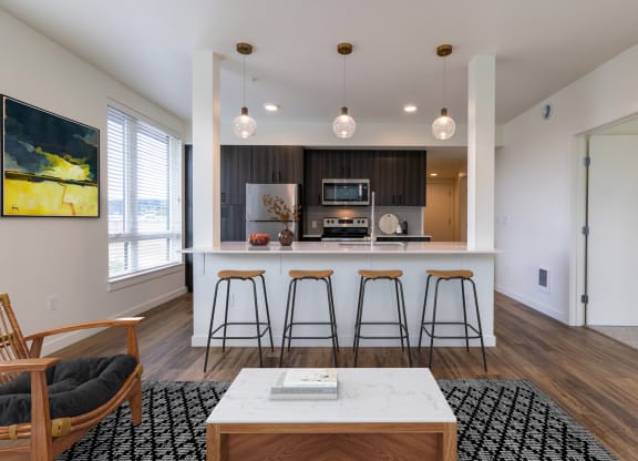 a kitchen with a large island and four stools in front of a counter top at Rivulet, Silverdale, 98383