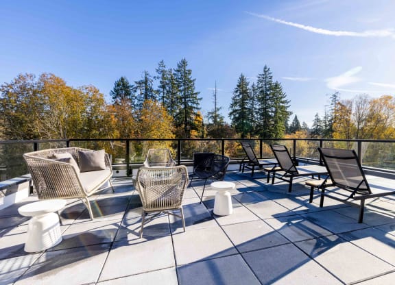a patio with chairs and tables on a balcony at Rivulet, Silverdale, WA