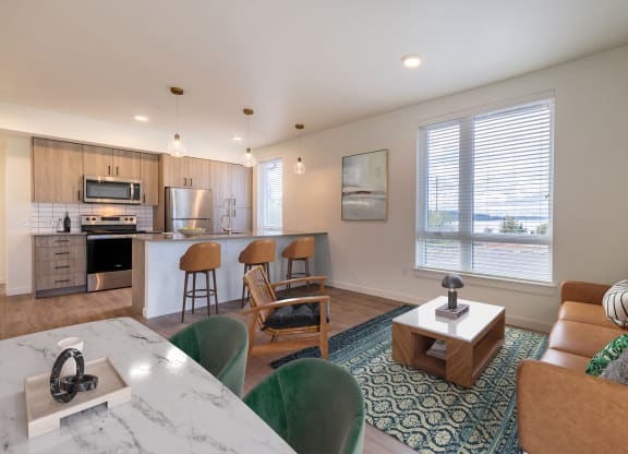an open living room and kitchen with a table and chairs at Rivulet, Silverdale, WA