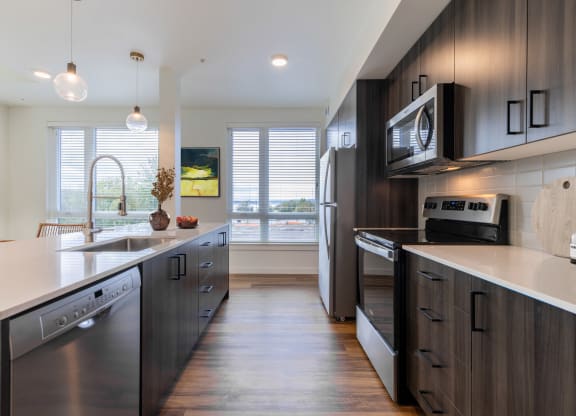 a kitchen with stainless steel appliances and wooden cabinets at Rivulet, Silverdale, 98383