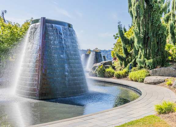 A water fountain in a garden with a clear blue sky.