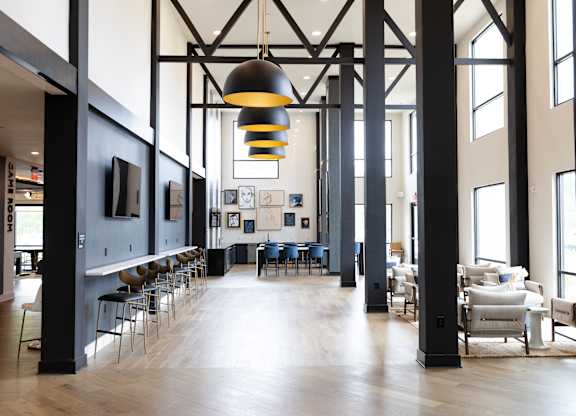 Community clubhouse with high ceilings and modern lighting at The Crest at South Point Apartments, Georgia