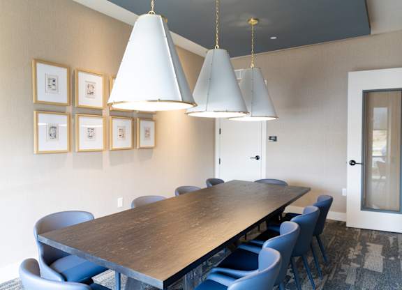 Conference room with large table and upholstered chairs at The Crest at South Point Apartments, McDonough, GA 30253