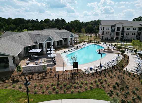 Resort style swimming pool with sun deck and lounge chairs at The Crest at South Point Apartments, McDonough