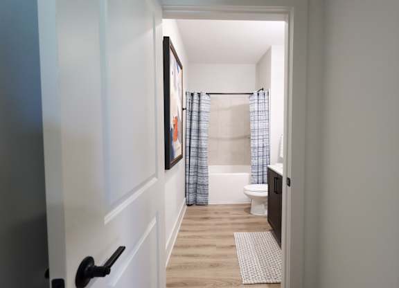 Bathroom with wood style flooring and toilet at The Crest at South Point Apartments, McDonough