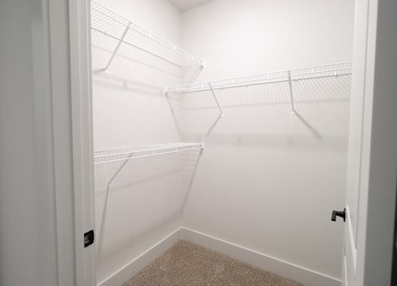 Walk-in closet with white wire shelving at The Crest at South Point Apartments, McDonough