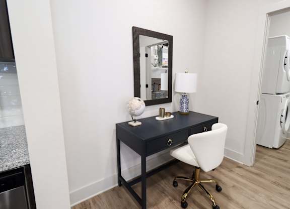 Home office nook with black desk and white chair at The Crest at South Point Apartments, Georgia