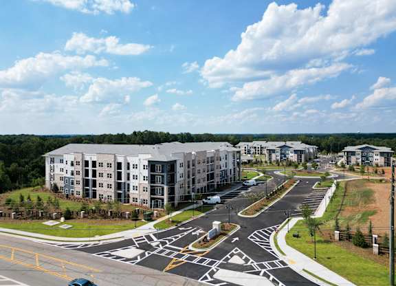 Aerial view of apartment buildings with entrance and parking at The Crest at South Point Apartments, McDonough, Georgia