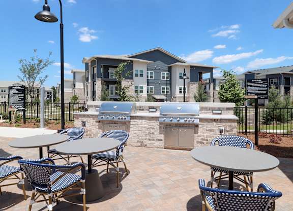 Outdoor grilling area with stone builtin bbq stations at The Crest at South Point Apartments, McDonough, 30253