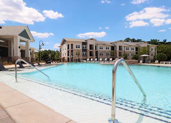 Large resort style pool with tanning shelf and cabana at The Crest at South Point Apartments, Georgia