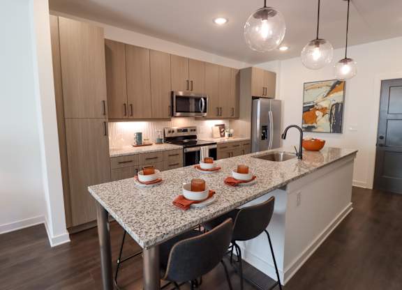 Modern kitchen with granite island seating for four at The Wren Apartments, Lawrenceville, GA