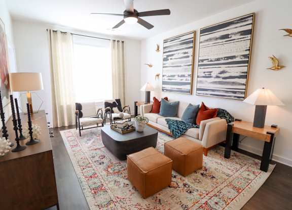 Living room with modern furniture and abstract artwork at The Wren Apartments, Lawrenceville, GA 30043