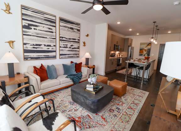 Furnished living area with modern decor and open kitchen at The Wren Apartments, Georgia