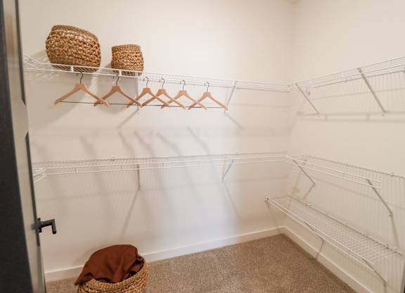 Walk-in closet with wire shelving and hangers at The Wren Apartments, Georgia, 30043