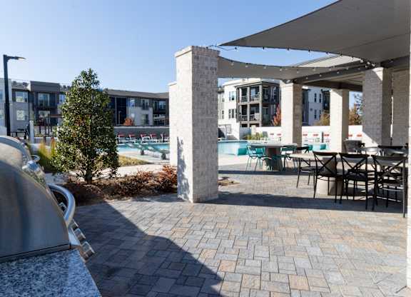 Outdoor patio with pergola and poolside dining at The Wren Apartments, Lawrenceville, 30043