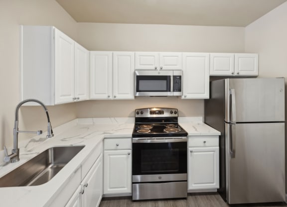 spacious kitchen with white cabinets and stainless steel appliances at Bridgeport Ranch apartments