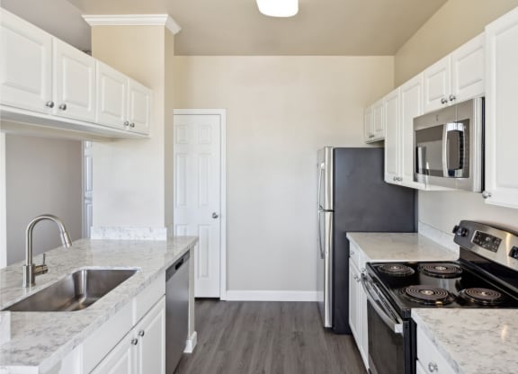spacious kitchen with white cabinets and stainless steel appliances at Bridgeport Ranch apartments