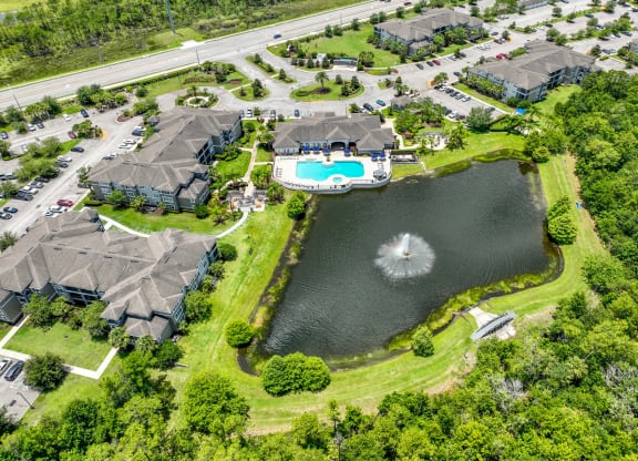 an aerial view of a neighborhood of houses and a lake with a fountain