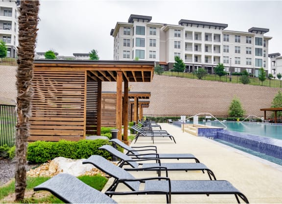 relaxing poolside lounging area at Reveal Skyline apartments