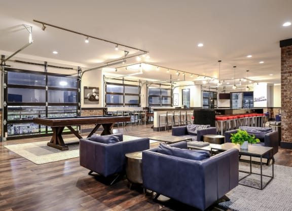 a lounge area with couches and tables and a pool table
