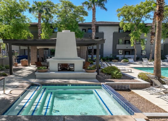 poolside covered lounging area with a fireplace at Avora apartments