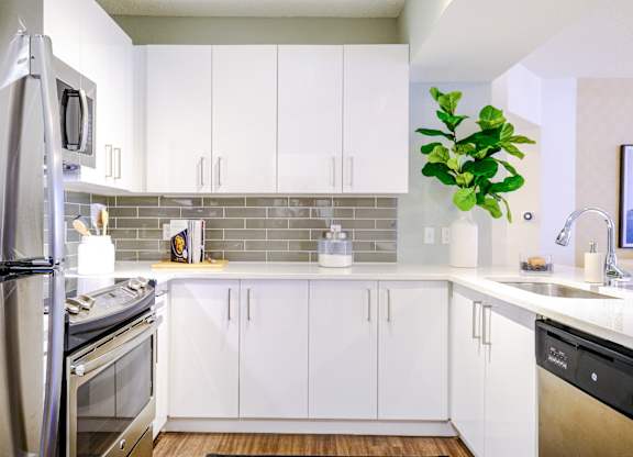 Kitchen with custom white cabinetry and stainless appliances at Sophia at Abacoa luxury Jupiter, FL apartments
