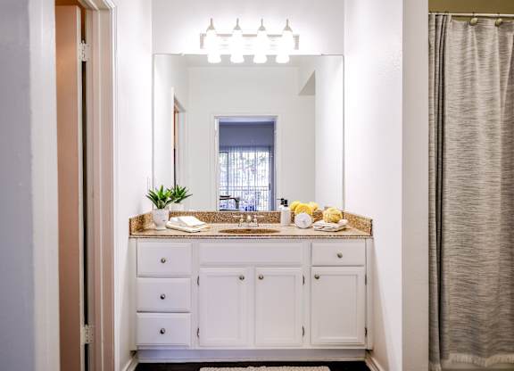 luxury bathroom vanity with custom cabinetry and designer lighting at San Marin apartments