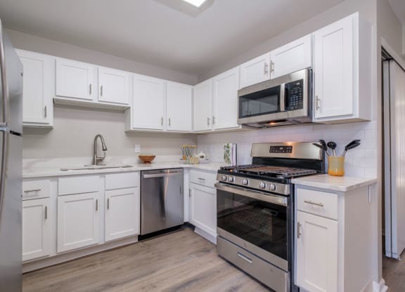 Heathermoor and Bedford Commons apartments kitchen with white cabinets and stainless appliances
